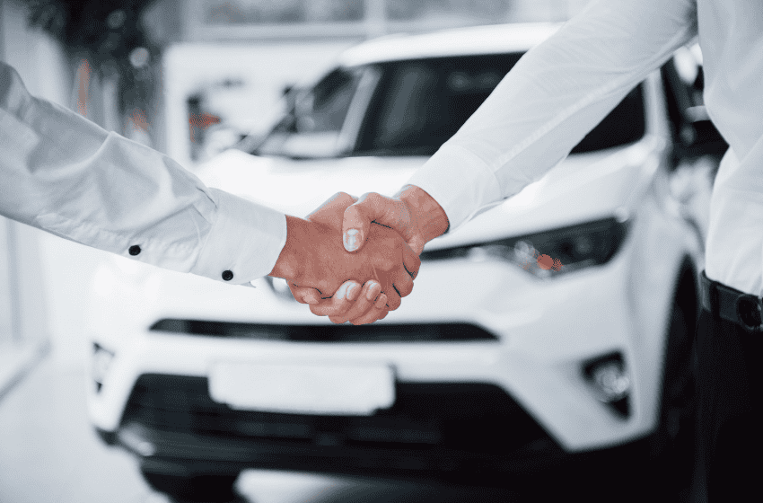 Handshake in front of car